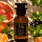a Pacific Chill inspired perfume, bottle on a beach amid grapefruit, fig and mandarin